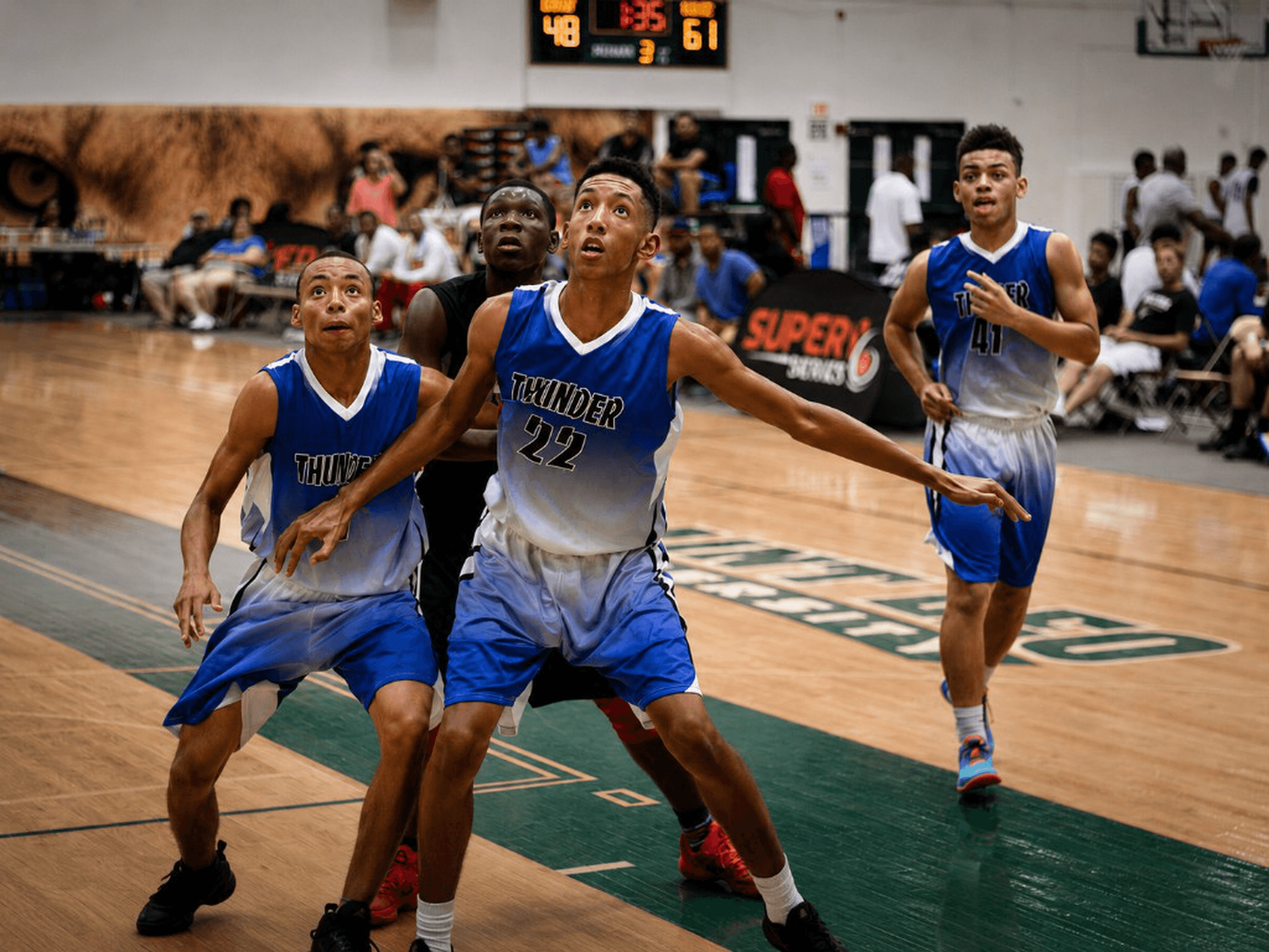 Thunder athletes boxing out under the scoreboard at a Super6 elite weekend.