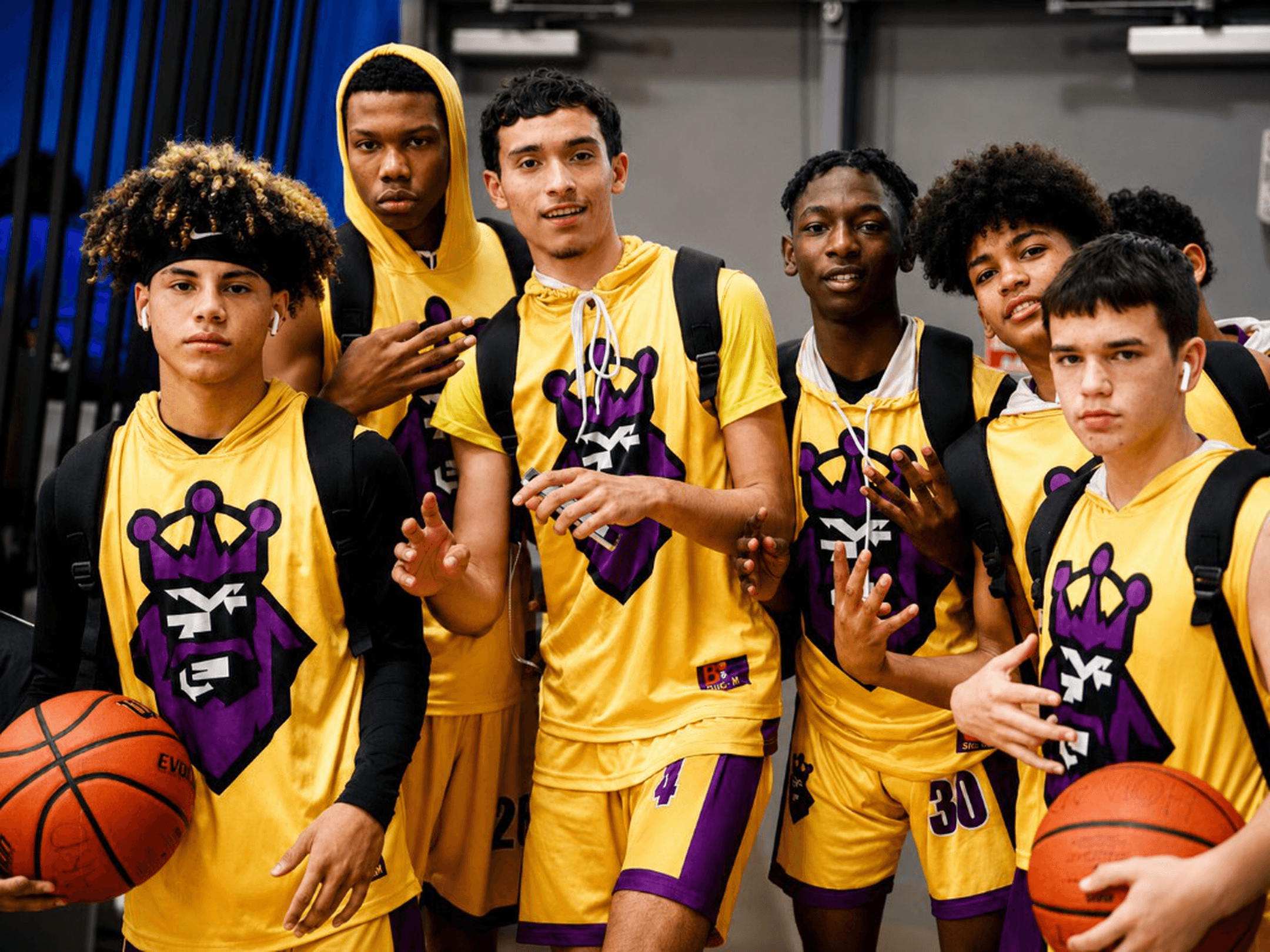 Six youth basketball athletes in yellow Super6 jerseys posing together at an indoor facility.