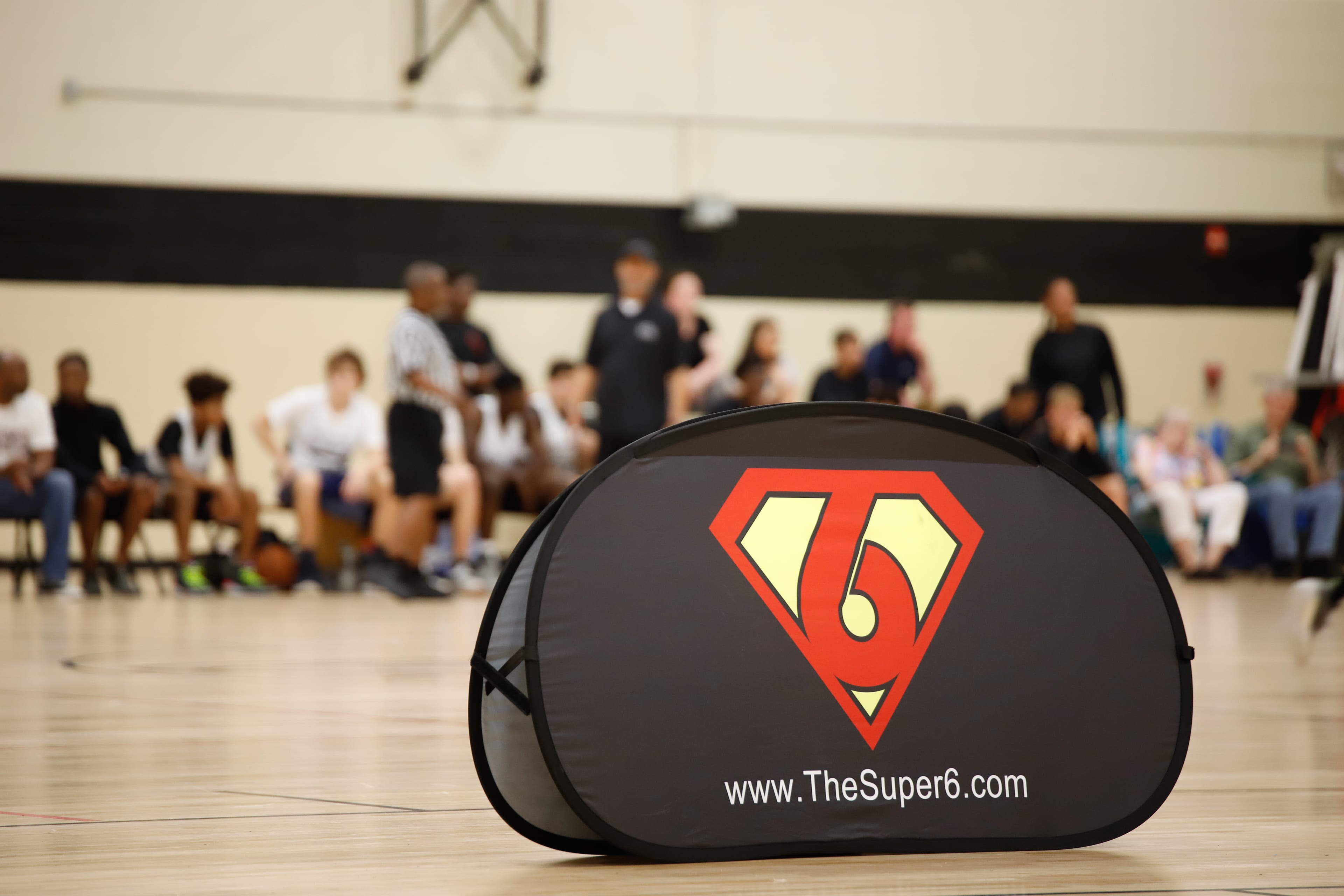 Super6 Series LLC banner in soft focus on the court