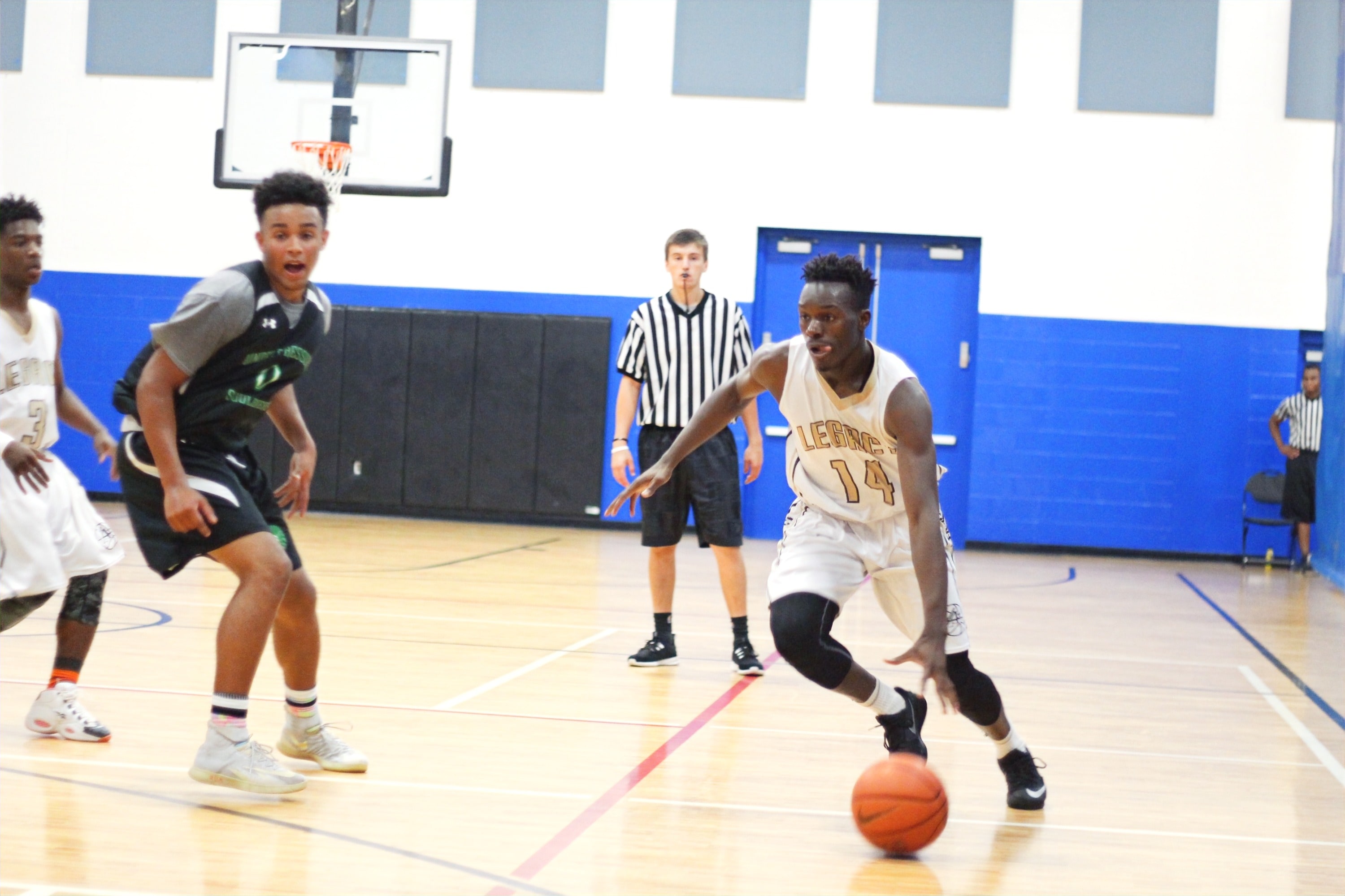 Player handling the ball with referee in background at the Ivy League Showcase