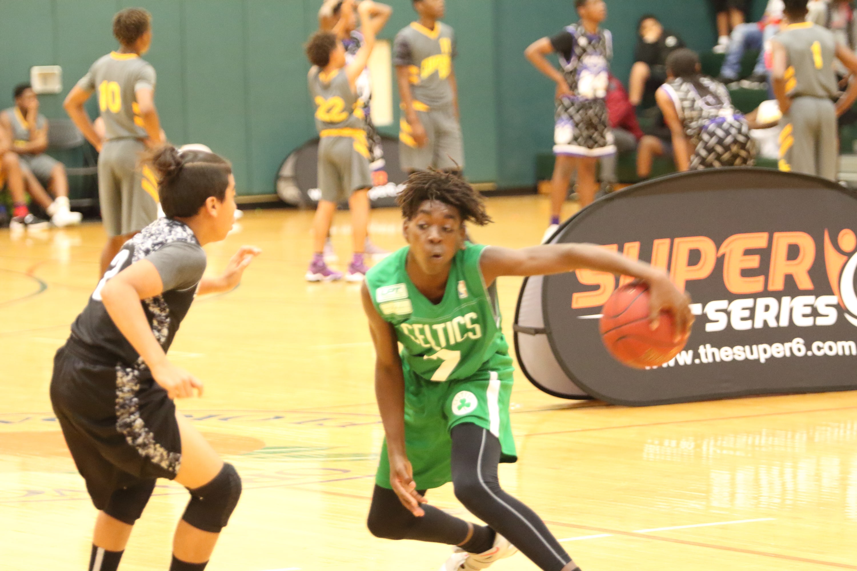 Celtics player driving past defender at the Ivy League Showcase