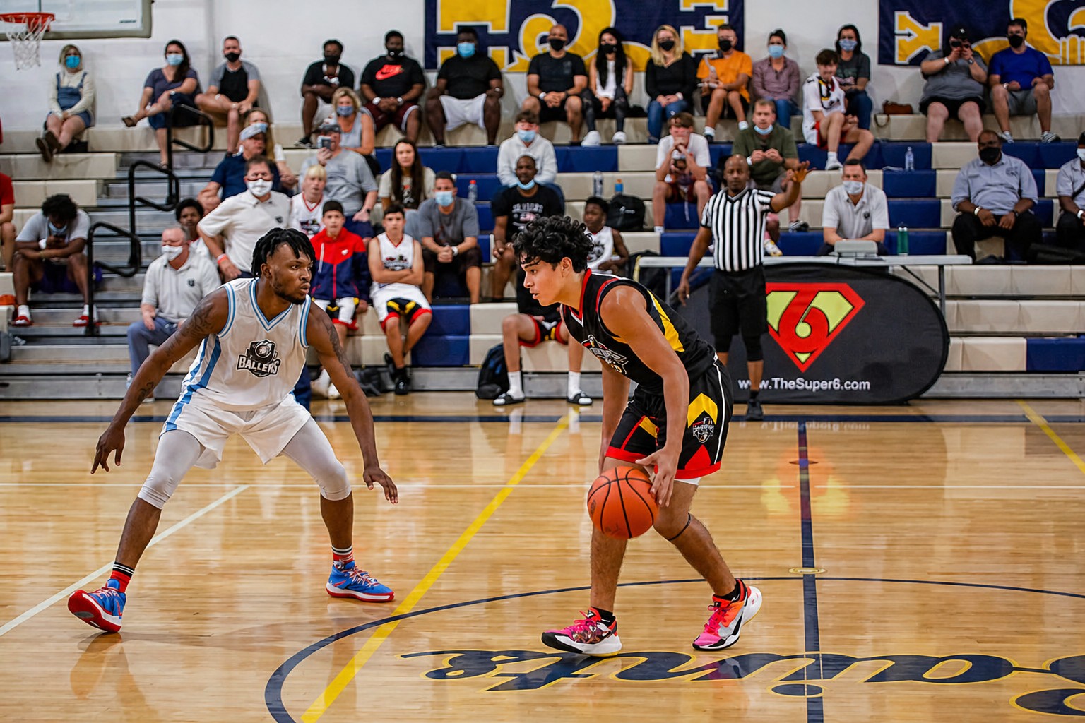 Youth basketball players competing in a Super6 Series LLC tournament game, orange jersey team on offense