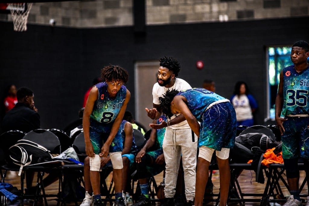 Coach talking with youth basketball players on the court