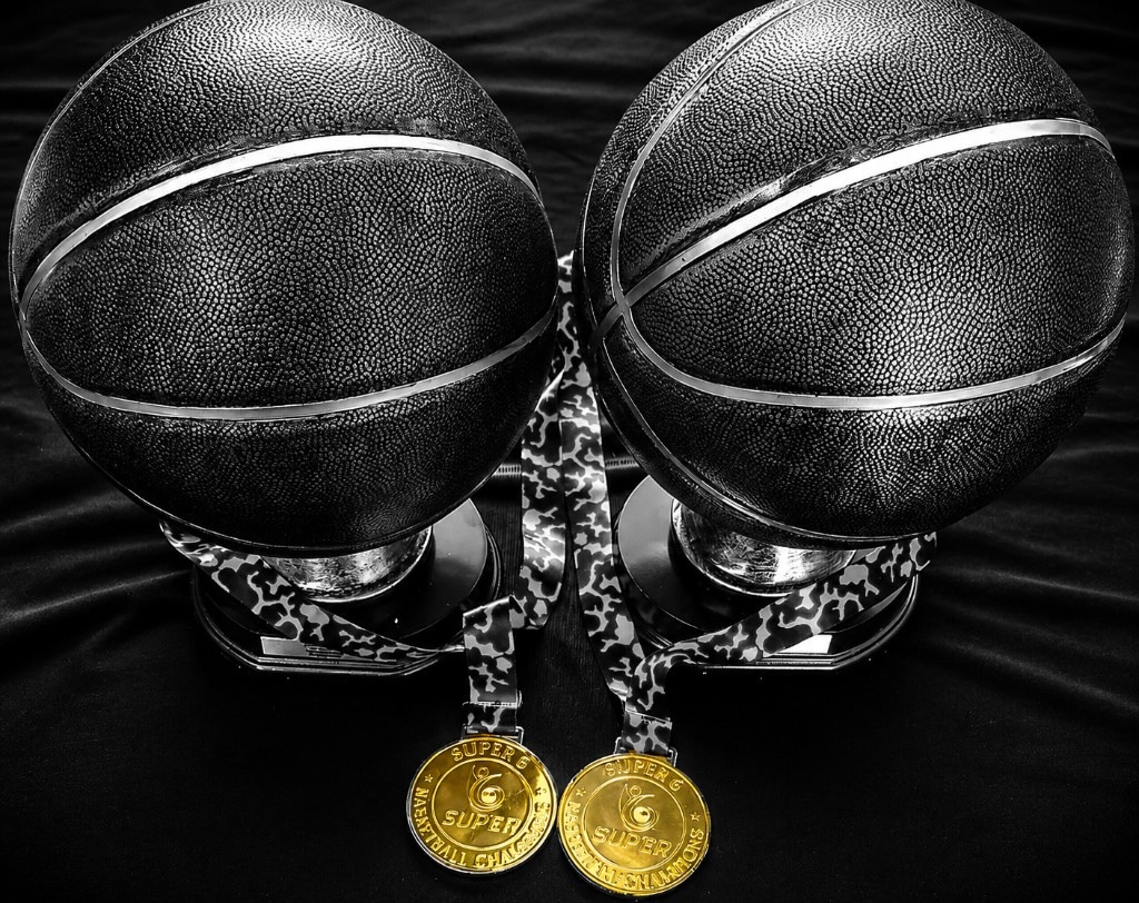 Two black basketball trophies with Super6 championship medals.
